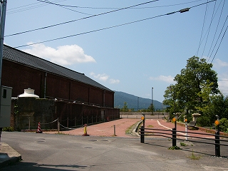 左に薄暗い色の赤レンガの倉庫、右手には他らしいレンガを敷き詰めた道。
