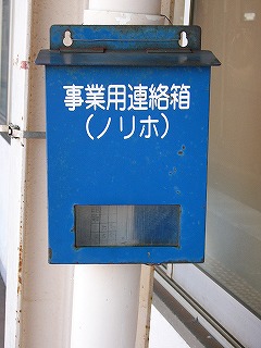 表に業務用連絡箱(ノリホ)と白字で書かれてある、個人宅に付けられてあるような縦長の小さなポストが青く塗られたようなもの