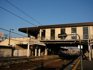 構内を跨ぐように作られた橋上駅。壁には等間隔に縦長の窓ガラスが入り、陸屋根の縁は焦げ茶色。