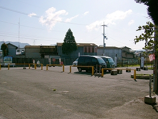 黄色い柵の内側に自動車が停められている。