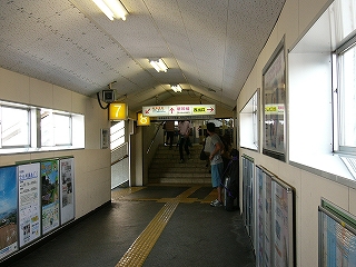 跨線橋を渡りきる頃になって、新幹線乗換改札への階段が跨線橋の狭い間口から見えている。