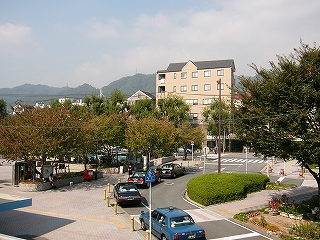 左にレンガ敷きの駅前広場と木々、右にロータリーとタクシー。