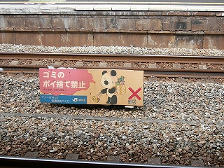 2線の間にある看板。「ゴミのポイ捨て禁止」と書かれ、右にはパンダのイラストが書かれている。