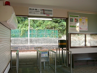 駅舎のホームへの間口にある、パイプの柵を組み合わせて作られた改札口を駅舎内から見て。
