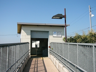 細いスロープを上った先にある陸屋根の小さな簡易駅舎。