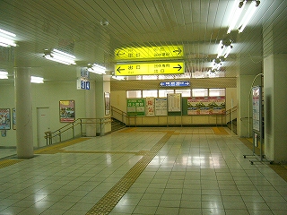 白い駅舎内。黄色い案内板。