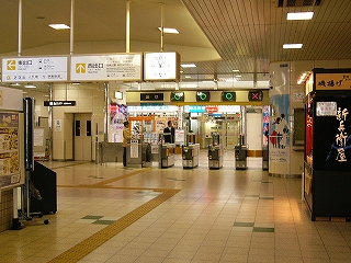 左に有人1レーン、自動改札4レーンの改札口。改札口の上にはマルやバツが表示され、入り口と出口を示している。