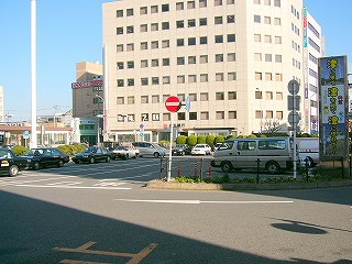 ロータリー真中部分に作られた駐車場、その奥に銀行の建物。