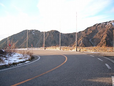 大日岳連峰と高原道路のカーブに立つポール
