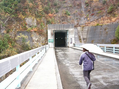 ダム堰堤上の道路に口をあけるトンネル