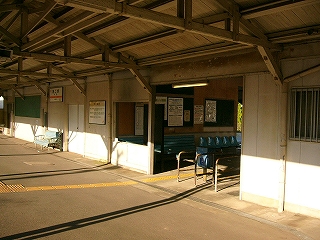 改札口の広い間口を斜めから見て。中央には青く塗られた、古くて大きな鉄製のきっぷ回収箱が置かれている。
