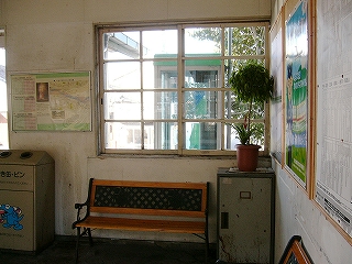 長椅子、汚い小さなロッカー、観葉植物、サッシでない窓。