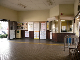 左手に駅舎出口、右端に出札口と改札口。正面の壁には掲示物が目立つ。