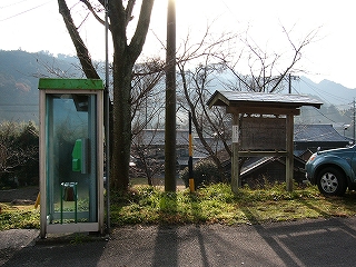電話ボックスとその横の木でできた屋根付きの大きな案内板。