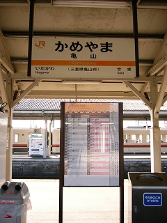 上には屋根から吊り下げられた駅名標、その下にホームに二本足で立つ駅時刻表。