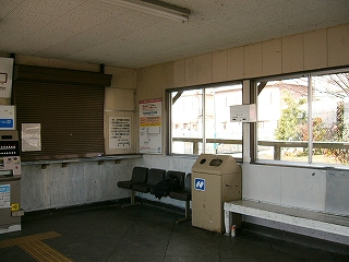 大きなサッシ窓のある駅舎内。そのふもとに長椅子が置かれている。