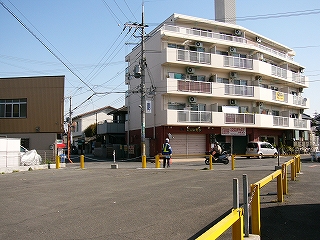 大きなマンションと黄色い柵で囲われたスペース。