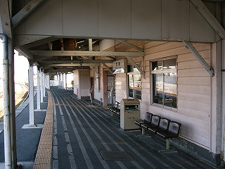 駅舎に向かって全体的に床面がスロープしている。駅舎の壁は木造でピンク色。