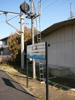 JR様式の駅名標と向こう側を向いた信号機。