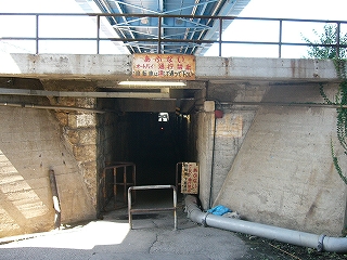 駅構内の下をくぐる古くて暗くて細い通路の入口前。