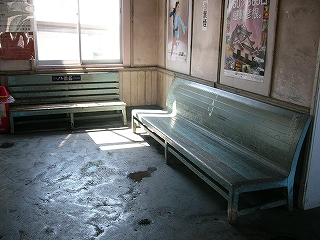 駅舎内の隅に設置されている2脚の木の長椅子。水色のペンキは長年の摩擦によりはげかかっている。
