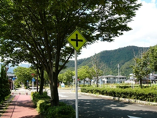 十字路の標識と緑地帯のある道路。