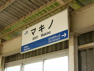 上屋と壁に接近して吊られた駅名標。
