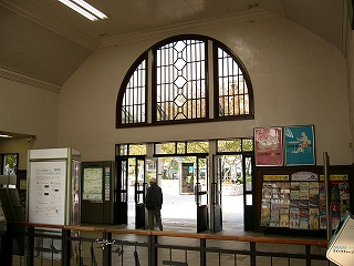 上の写真の右側にあたる。上方に模様入りの枠のついた半円の大きな窓、その下に駅舎への出口。