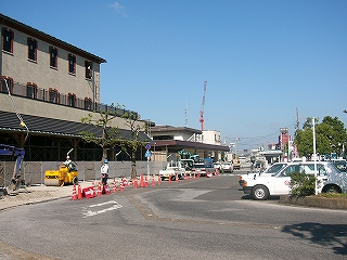 左手に新築された駅舎、正面にロータリーの道路の一部。