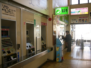 3台の券売機。その向こうに「指定券」の緑色の電照式案内板が出ている。