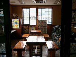 奥に窓のある一室に明るい木製の椅子と机