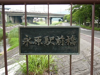 黒地に金字で「永原駅前橋」と表された銘板