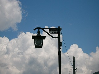 S字の棒にぶら下がるように取り付けられた、電球の入った四角い街灯。