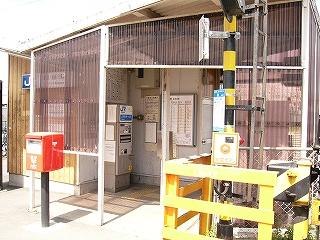 踏切信号機の柱と簡易駅舎。中に券売機。