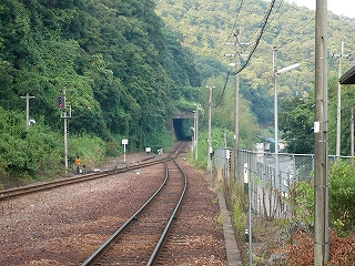 左にはすぐにこんもりとした山の緑が差し迫り、右は銀色のフェンスのしつらえてある線路内。先のほうで再び単線になり、短いトンネルを控えている。