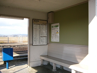 白い木製の長椅子の上には天井まで広がった薄い緑の掲示板が取り付けられてあった。