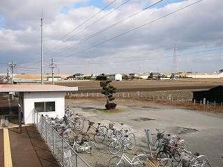 左に簡易駅舎、右手からこちら側に向かって自転車が並んでいる。