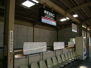 一人掛けの椅子の並びと上屋から吊るされた駅名標。