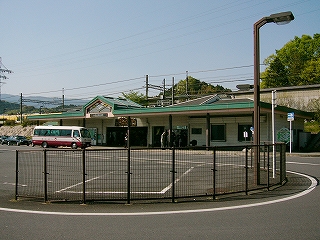 柵で囲まれたロータリーと駅舎。