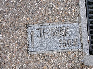 地面に埋め込まれた、「JR関駅350米」と彫られた小ぶりな大理石。