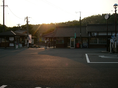 暗い夕日とどっしりした日本の瓦屋根の駅舎
