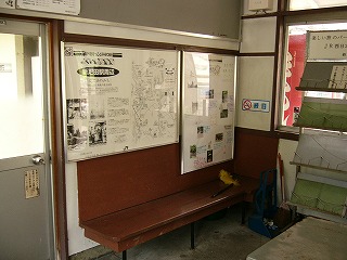 壁に据え付けられた茶色の椅子と壁の掲示物