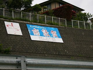 カーブの壁面に掛けられた青地にはげかかった赤字で「南敦賀」と書かれた大きな看板