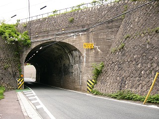 濃い赤茶に焼けた石垣に古いコンクリート製のトンネル