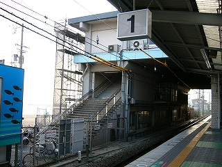 橋上コンコースから足を出すように、駅構外へ出る階段降り口。