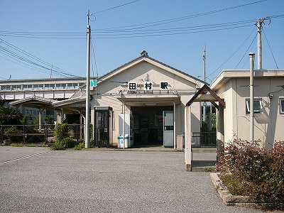 妻面に出入口のある瓦葺コンクリートの駅舎。出入口上部に田村駅との表示。