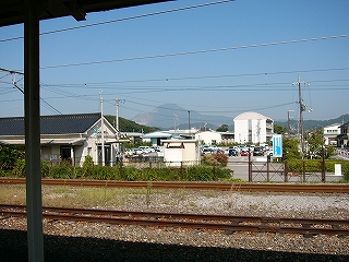 線路の越しに見る駅舎出入口と駅前。ずっと遠くには伊吹山が見える。