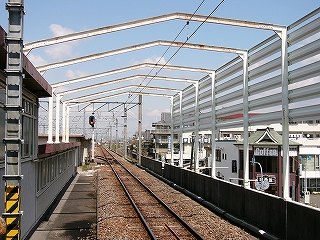 駅舎の鉄骨の枠に架線が吊るされた風景。