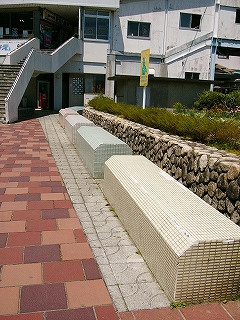パステルカラーの小さいタイルをいっぱいに貼り付けたコンクリートの長椅子。