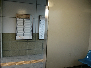 ステンレスの間口から見た駅舎内の通路。時刻表が見えている。
